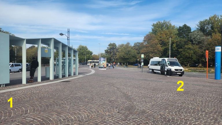 1 = the bays for the regular city bus, bay A1 is to the left of the image; 2 = the shuttle bus waiting at its stop